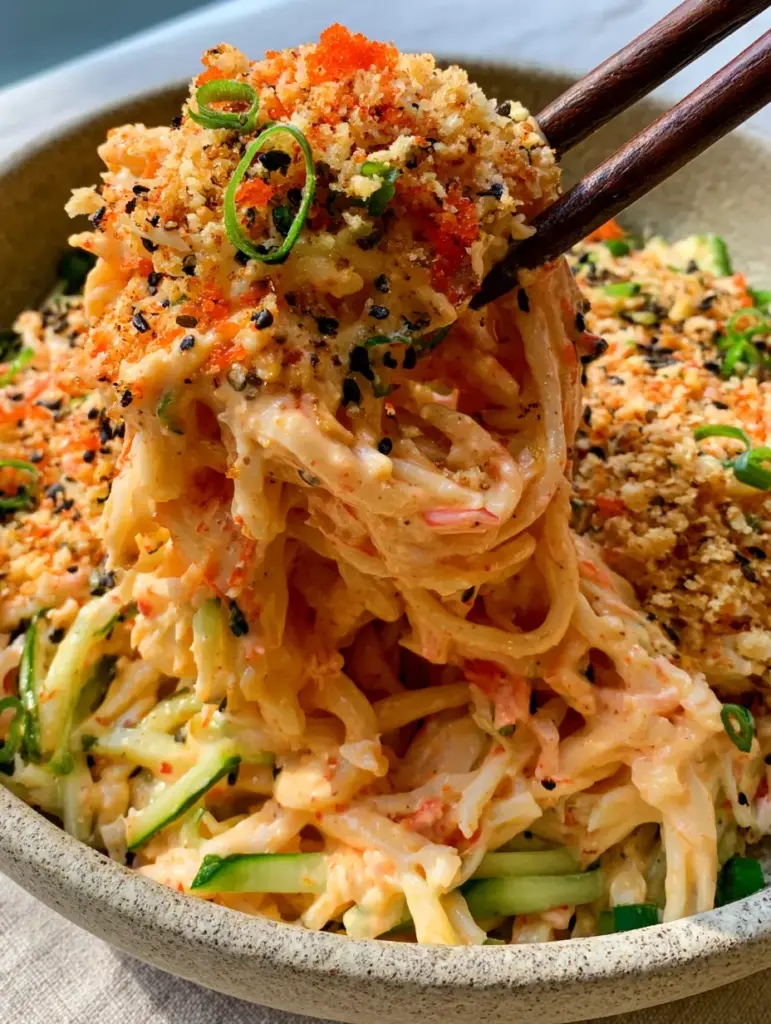 Cucumber Crab Salad: The Ultimate Spicy Kani Salad with Signature Crunch 1 A top-down view of Cucumber Crab Salad in a stone bowl featuring toasted panko, masago, and black sesame seeds.