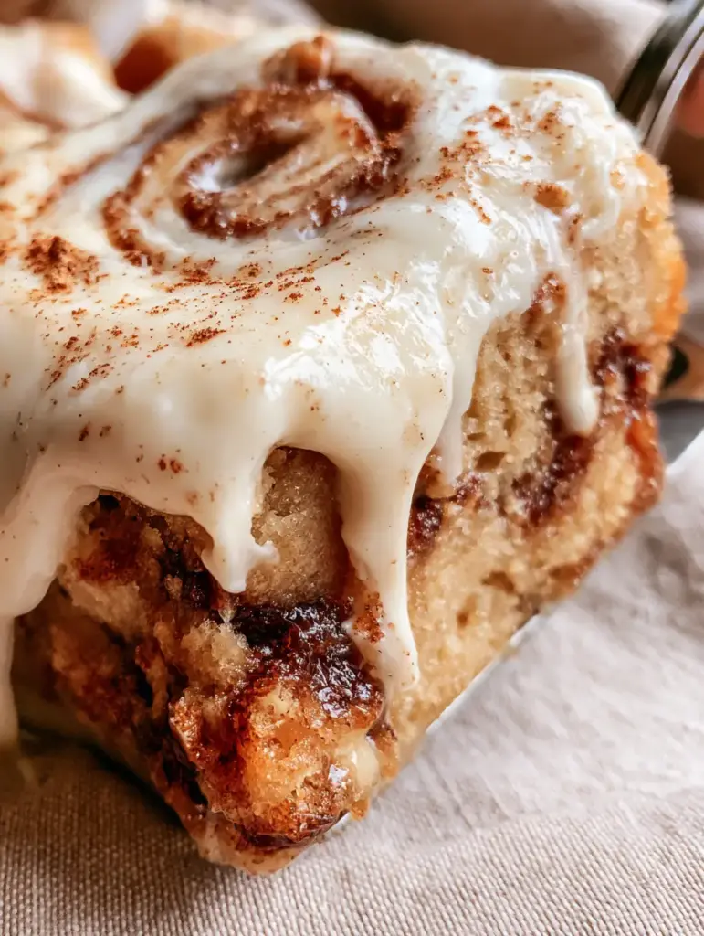 Top view of Cinnamon Roll Bliss Bars with glossy cream cheese frosting and a translucent sugary glaze drizzle.