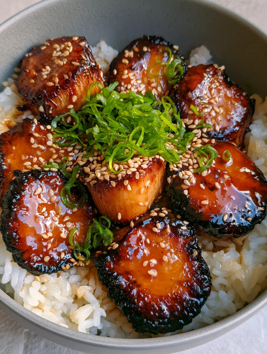 Thick-cut seared King Oyster mushroom medallions drenched in a reflective teriyaki glaze.