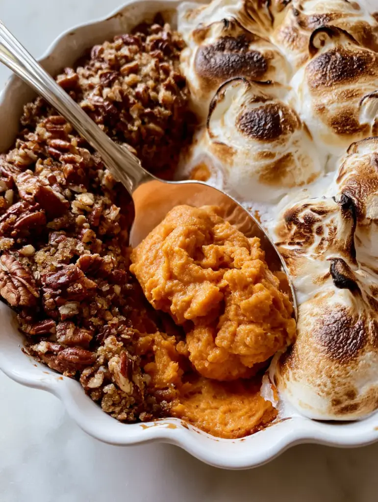 Sweet potato souffle: The Ultimate Fluffy Holiday Side Dish 1 A silver spoon lifting a scoop of fluffy Sweet potato souffle from a scalloped ceramic dish.