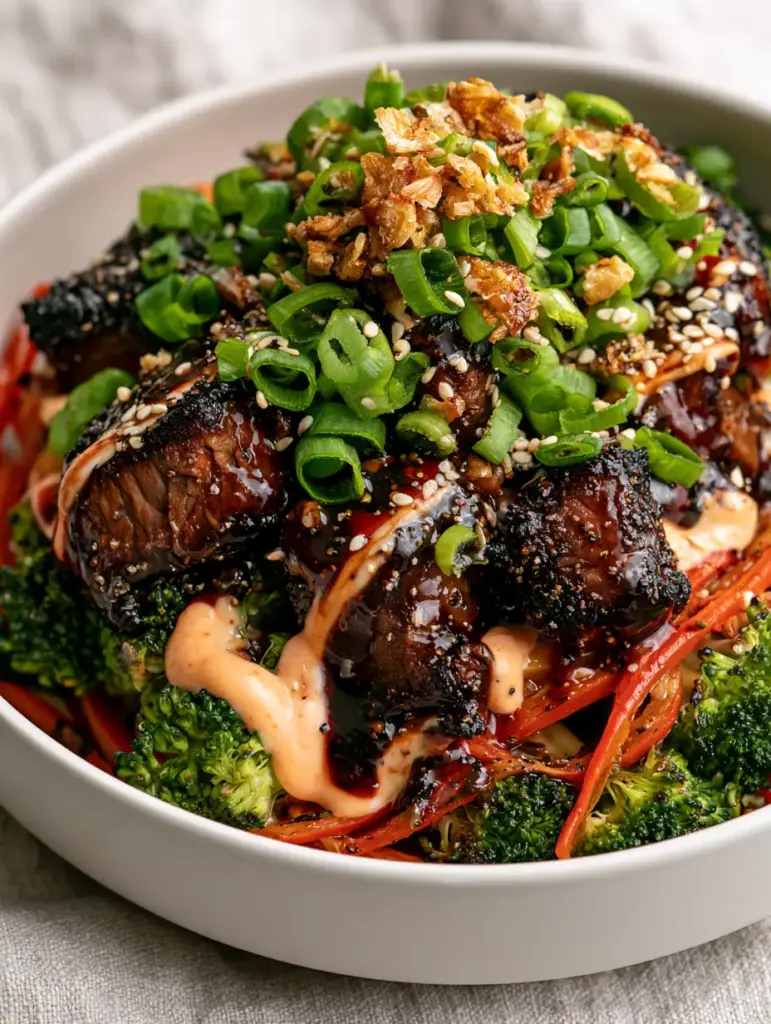 High Protein Meal Plan: Umami Glazed Steak and Garlic Broccoli 1 Macro shot of steak meal prep bowl with sriracha mayo drizzle, sesame seeds, and crispy garlic. (High protein meal plan)